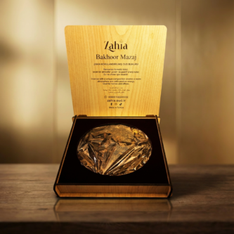Firefly_Gemini-Flash_Place-the-uploaded-perfume-bottle-on-the-wooden-table-in-the-uploaded-background._Rem-194167-333x333 البخور اليمني الفاخر من زاهية للأعراس والمناسبات والضيافة الراقية